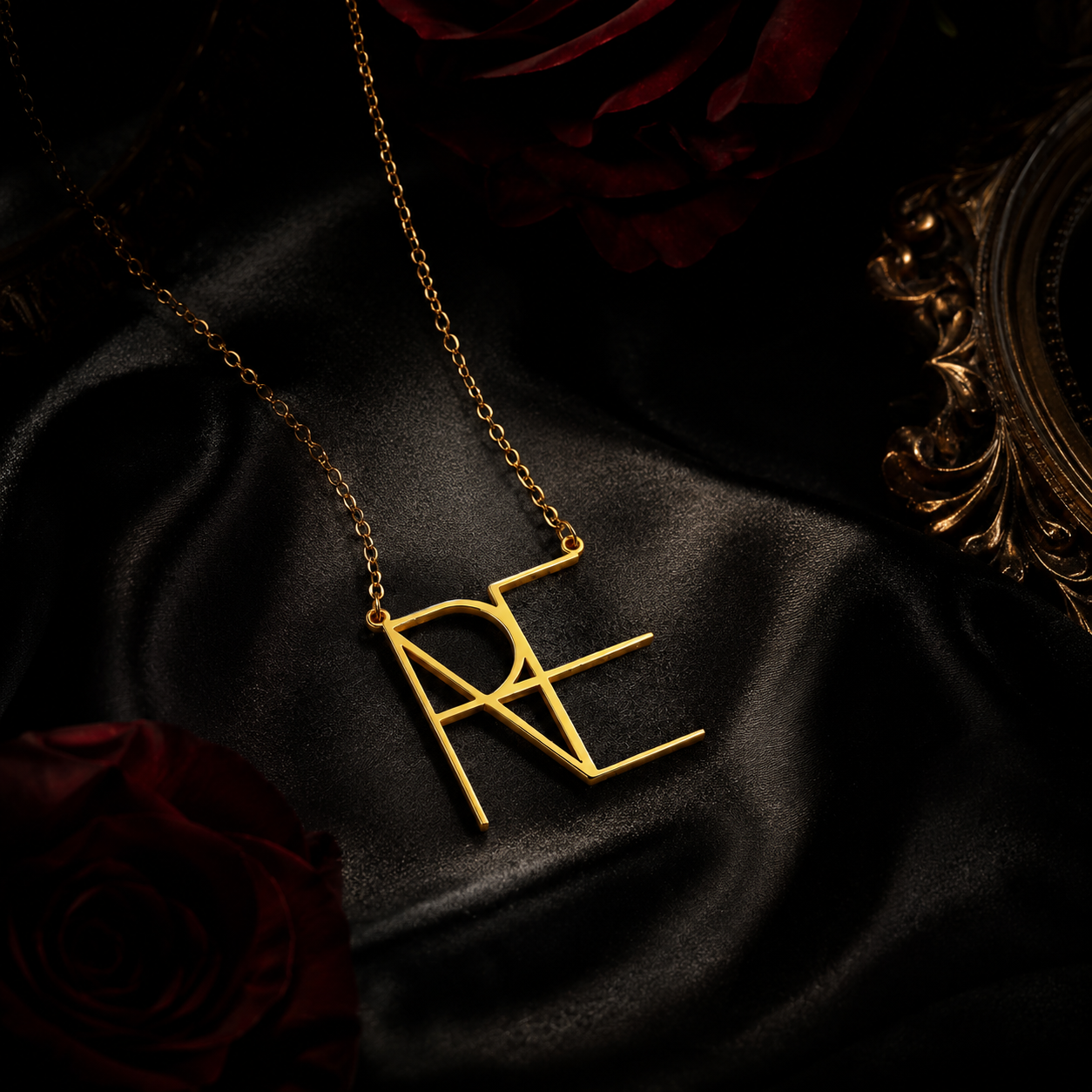 Custom gold geometric name pendant photographed on black satin